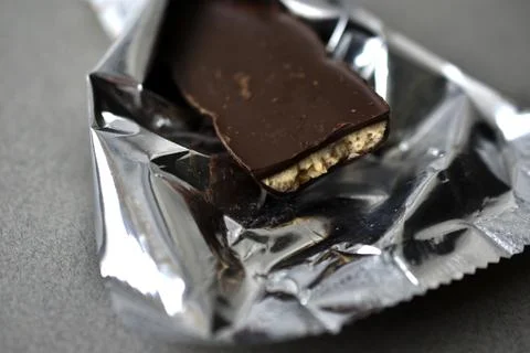 Chocolate candy in a wrapper on a gray background Stock Photos