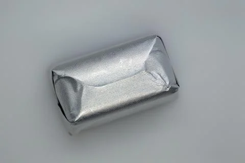 Chocolate candy wrapper in silver color. gray background. Isolated. Stock Photos