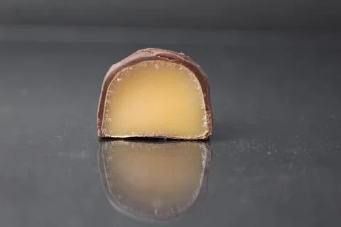 Chocolate case candy in section with yellow brown fruit filling praline Stock Photos