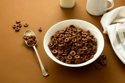 Chocolate cereal rings in bowl brown background. Breakfast for kind. Stock Photos