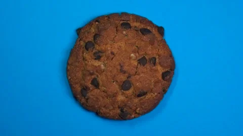 Chocolate chip cookie close-up, macro shot, fast spinning on a rotating blue Stock Footage 89309157