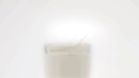 Chocolate chip cookie falls in slow motion into a glass of milk Stock Footage 70679257