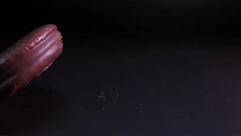 Chocolate chip cookie falls into table surface in slow-motion with crumbs flying Stock Footage 280686312