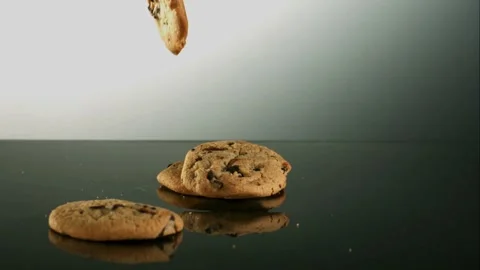 Chocolate chip cookies falling on a surface Stock Footage 327052072