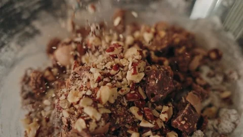 Chocolate chips and walnuts falling into cookie dough slow motion Stock Footage 327367387