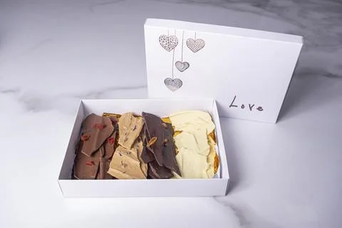 Chocolate chips of different flavors inside a white box. Stock Photos
