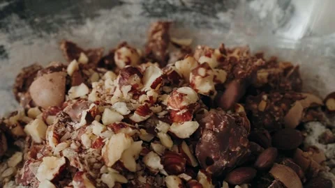 Chocolate chips falling into bowl with nuts in slow motion Stock Footage 327449037
