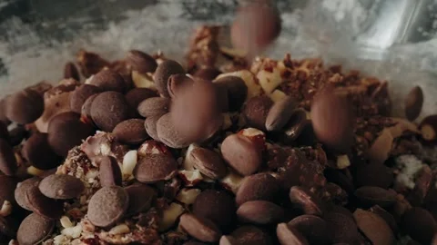 Chocolate chips falling onto dough with walnuts slow motion close up Stock Footage 327367611