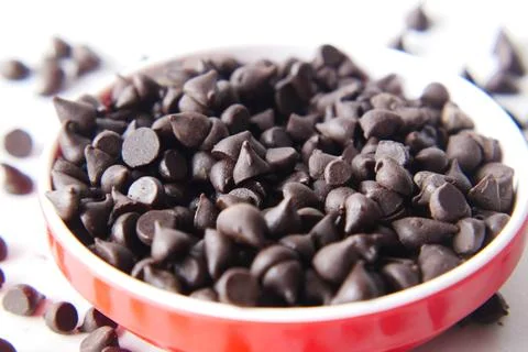 Chocolate chips spilling from a plastic packet, Stock Photos