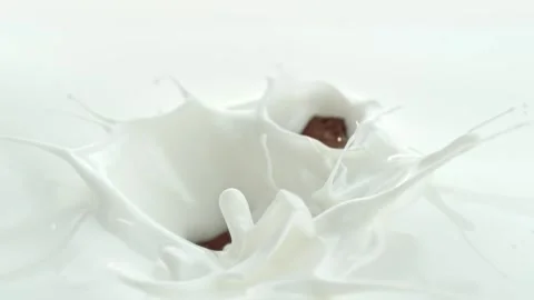Chocolate Chunks Falling into Creamy Milk Making Swirly Splashes in Macro Stock Footage 274354988