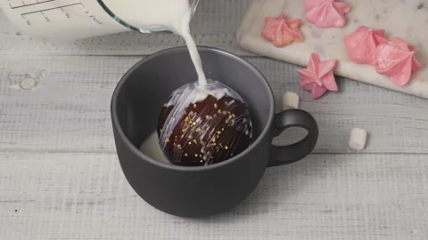 Chocolate cocoa bomb with mini marshmallows melts with hot milk. Stock Footage 157230150