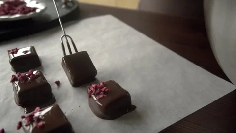 Chocolate confectioner puts handmade chocolates on a special table Stock Footage 72529341