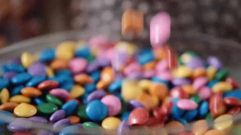 Chocolate confetti falling in slow motion into a bowl Video stock 128018387