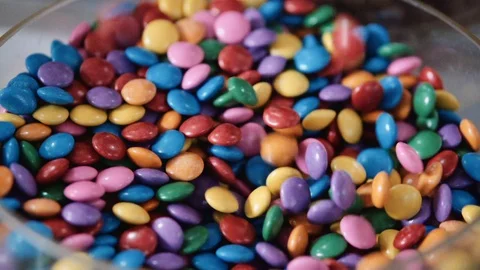 Chocolate confetti falling in slow motion into a bowl Stock Footage 128018459