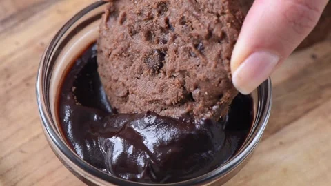 Chocolate cookie dipping into dark melted sauce in slow motion. Stock Footage 339751257