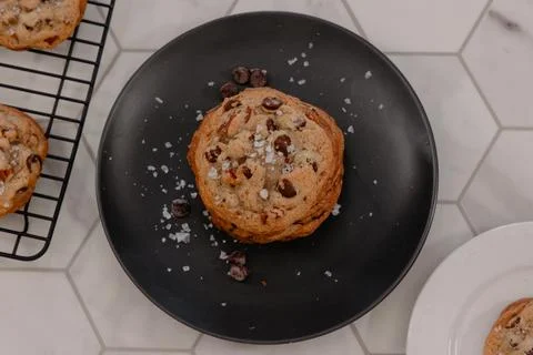 Chocolate cookie stack covered in salt surrounded by other cookies Stock Photos