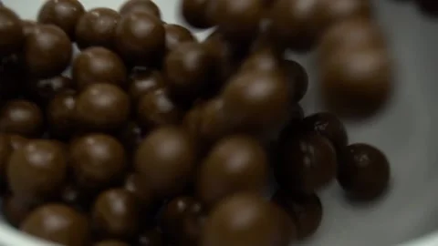 Chocolate Corn Balls Are Falling Into The Plate. Slow Motion Stock Footage 86994417