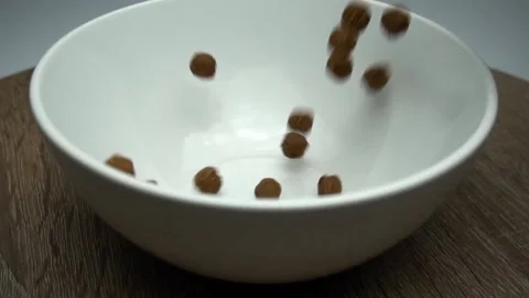 Chocolate Corn Balls Are Falling Into The Plate. Slow Motion Stock Footage 86994615