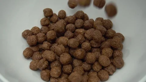 Chocolate Corn Balls Are Falling Into The Plate. Slow Motion Stock Footage 86995214