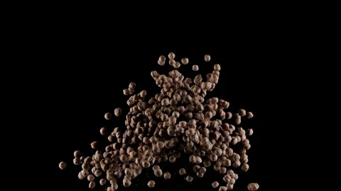 Chocolate corn cereal balls exploding in slow motion, isolated black background Stock Footage 141985003
