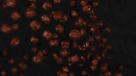 Chocolate corn cereal balls moving up and down on a black background. Stock Footage 144992216