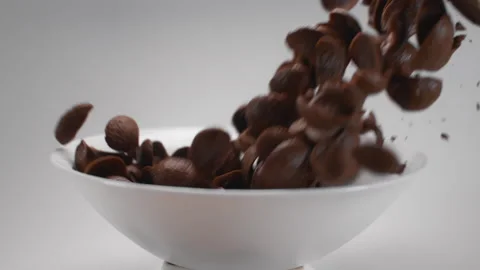 Chocolate corn flakes and milk are falling to the white bowl in slow motion Stock Footage 143780378