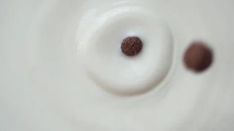 Chocolate corn flakes falling into the bowl with milk. Stock Footage 129234738