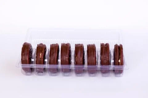 Chocolate covered biscuits lined up in a transparent box Stock Photos