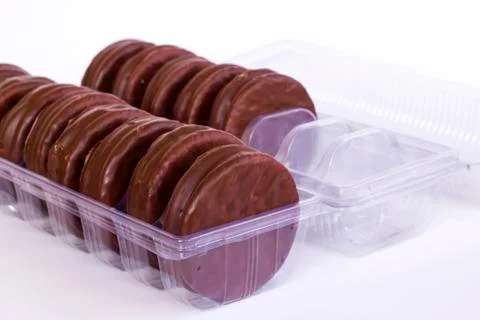 Chocolate covered biscuits lined up in a transparent box Stock Photos