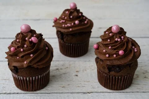 Chocolate cupcake with decorative ball. Rustic wood background Stock Photos