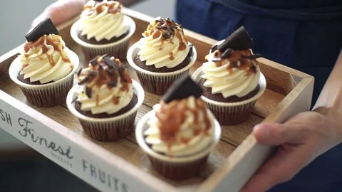 Chocolate cupcake on a tray in hands Stock Footage 75191083