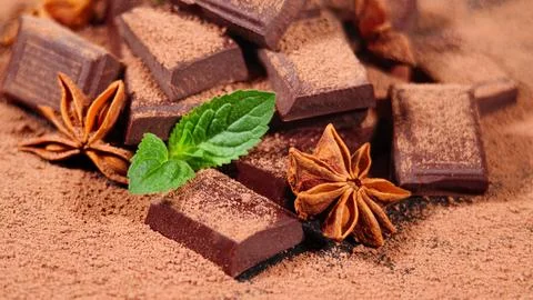 Chocolate. Dark Chocolate Bar Stack and Cocoa Powder with Mint Leafs and Anise Stock Photos