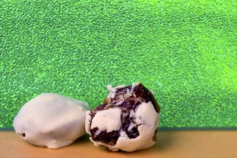 Chocolate dates with bites and alone, bright green background is very much .. Stock Photos