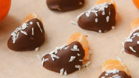 Chocolate-dipped mandarin slices with coconut Video stock 70139743