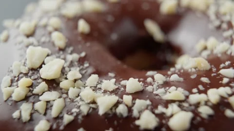 Chocolate donut with nut sprinkles. Macro. Unhealthy food. Bakery and concept. Stock Footage 302009147