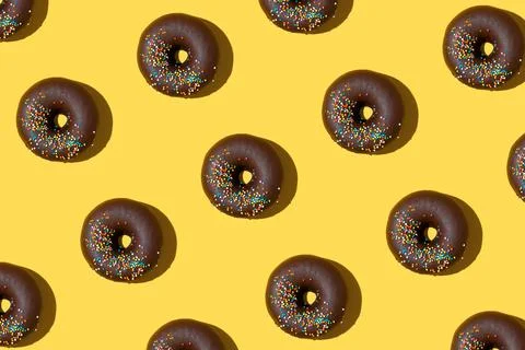 Chocolate donuts pattern on yellow background. Top view, flat lay Foto stock