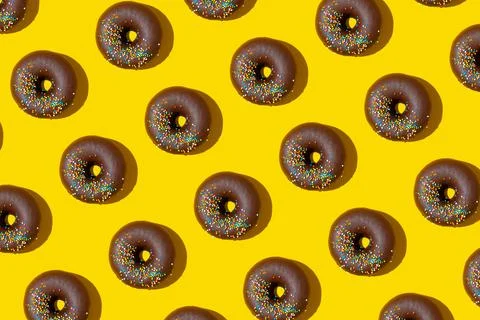 Chocolate donuts pattern on yellow background. Top view, flat lay Foto stock