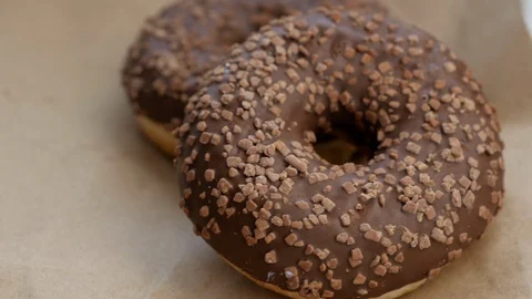 Chocolate donuts rotating on craft paper Stock Footage 108166379