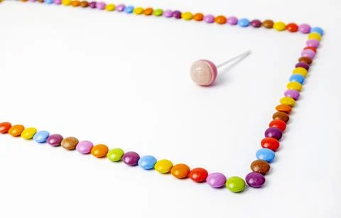 Chocolate dragees lined with rectangle on white background. Frame of colorful Stock Photos