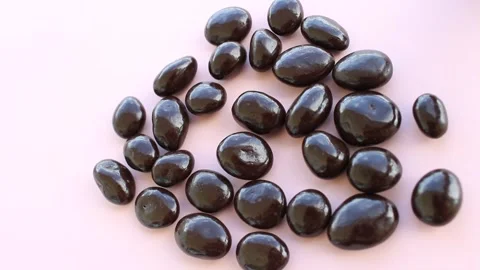 Chocolate drops on pink background, dark chocolate coverd nuts, top view Stock-Footage 160165938