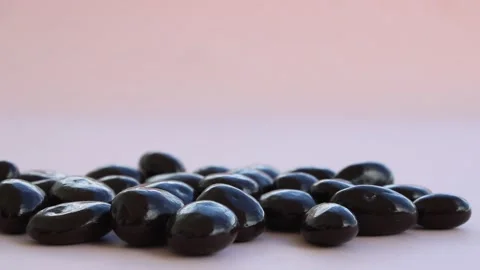 Chocolate drops on pink background, dark chocolate coverd nuts Stock-Footage 160165967
