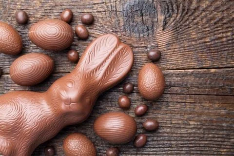 Chocolate Easter bunny and eggs on wooden background Stock Photos