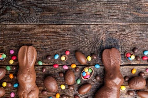 Chocolate Easter bunny and eggs on wooden background Stock Photos