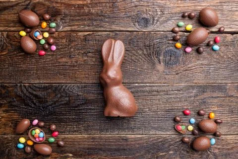 Chocolate Easter bunny and eggs on wooden background Stock Photos
