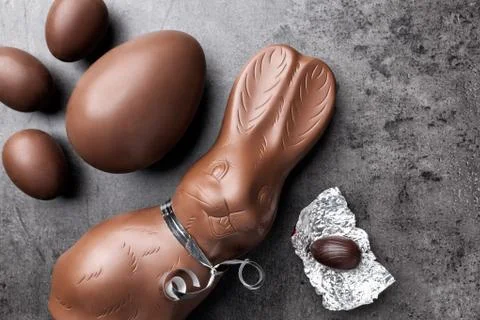 Chocolate Easter bunny and eggs on rustic background Stock Photos