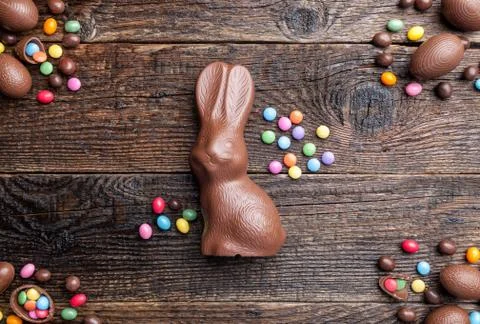 Chocolate Easter bunny, eggs and sweets on rustic background Stock Photos