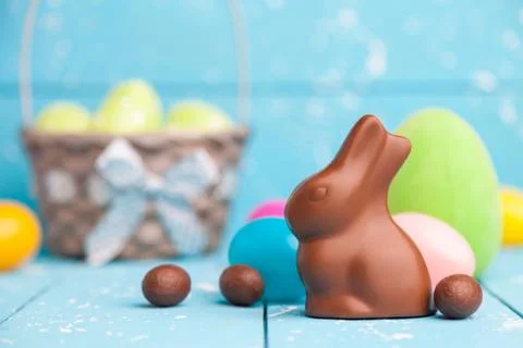 Chocolate Easter bunny, eggs and sweets on rustic background Stock Photos