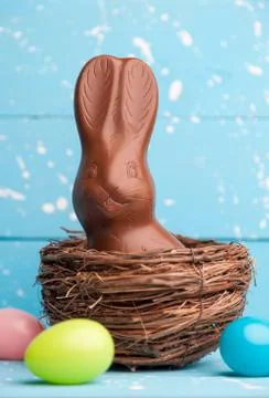 Chocolate Easter bunny, eggs and sweets on rustic background Stock Photos