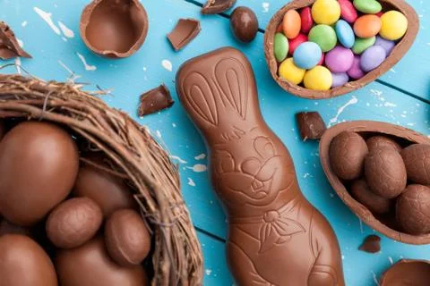 Chocolate Easter bunny, eggs and sweets on rustic background Stock Photos