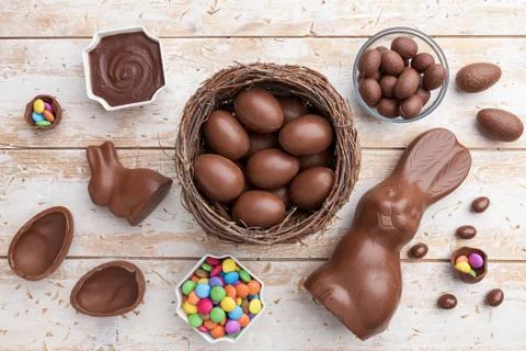 Chocolate Easter bunny, eggs and sweets on rustic background Stock Photos